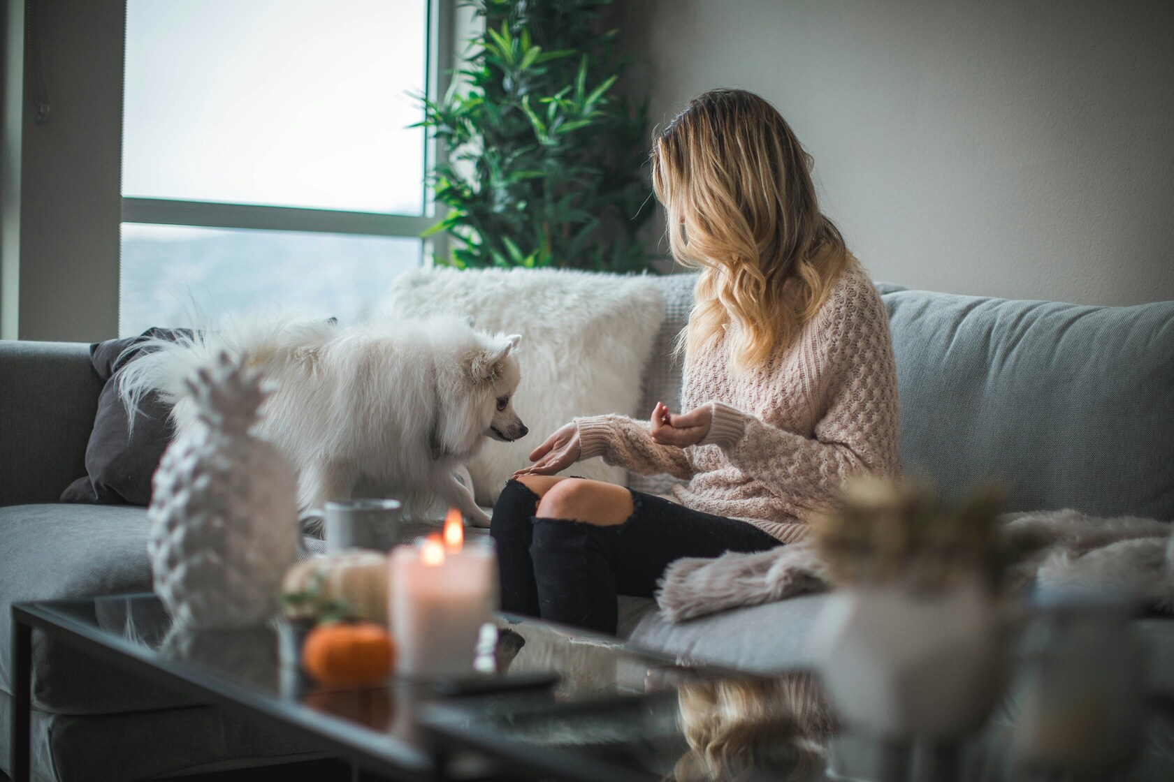 Vrouw thuis met haar hond op de bank