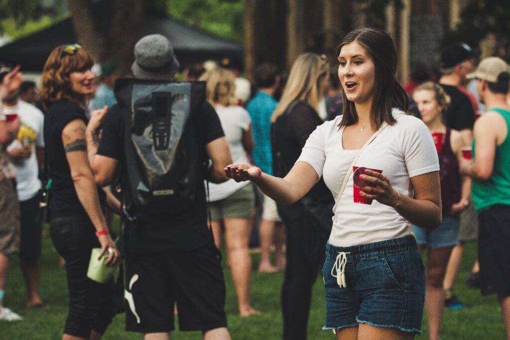 Bezoekers in casual festivaloutfits met drankjes tijdens een zomers buitenfestival