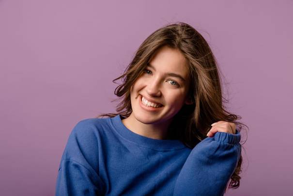een vrouw kijkt naar de camera en kijkt lachend