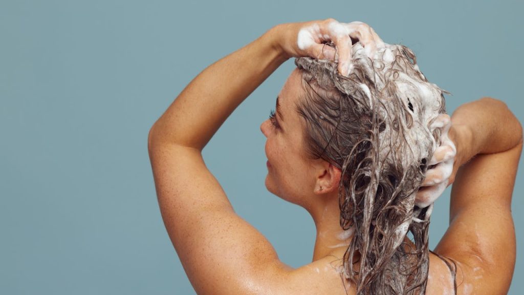Vrouw wast haar met de juiste haarreiniger voor haar haartype