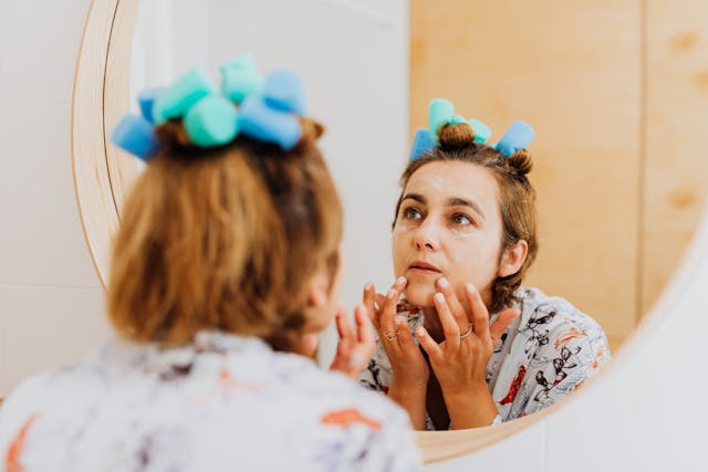 Mevrouw is kijkt in de spiegel naar haar oudere huid