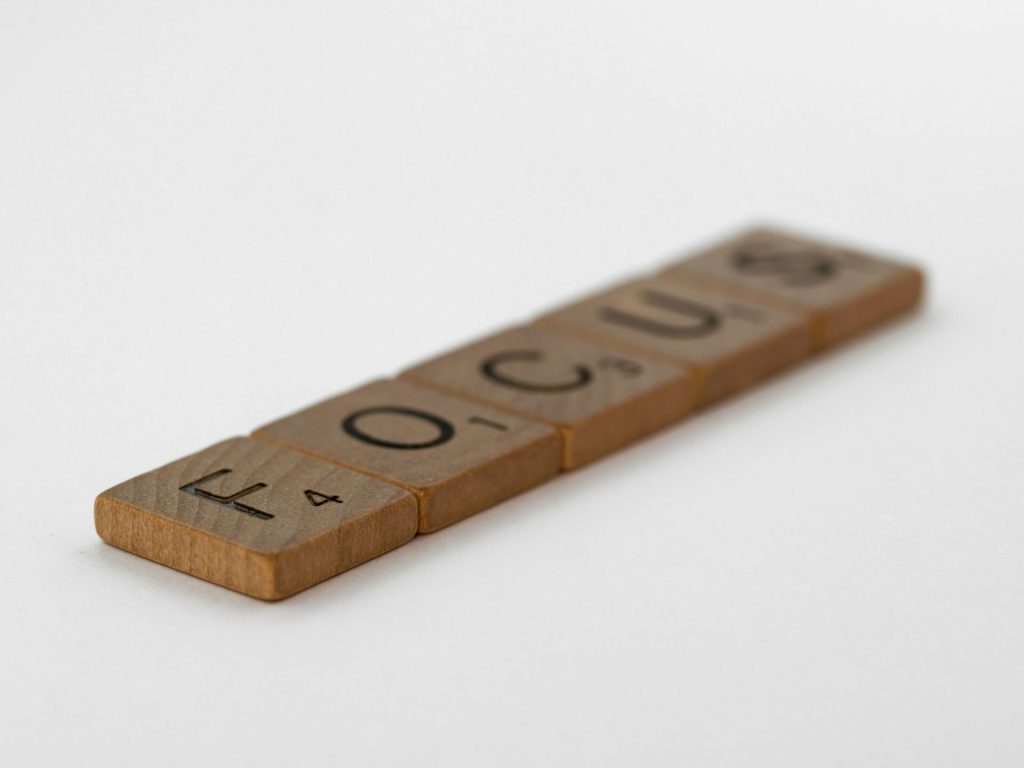 Houten letters vormen het woord focus als symbool voor mentale helderheid en concentratie.